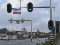 902665 Afbeelding van twee omgekeerde Nederlandse vlaggen op een verkeerslichteninstallatie boven de provinciale weg ...